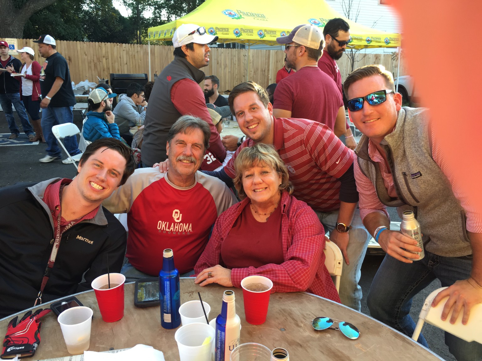 Five Oilfield Tailgate guests wearing crimson OU colors gathered outdoors on November 12, 2016