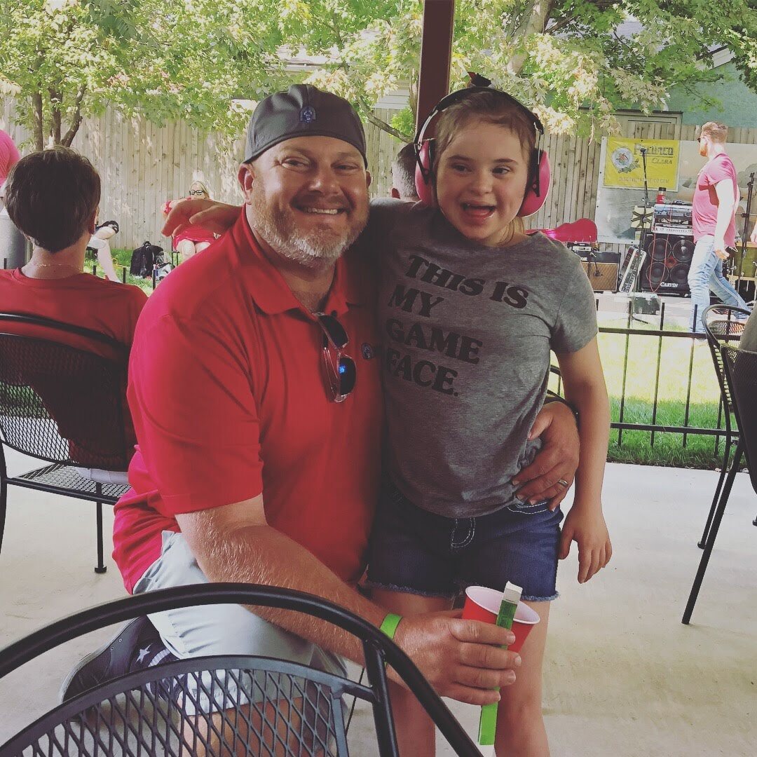 Matt Hill and a young Oilfield Tailgate guest smiling near the live music stage in 2018